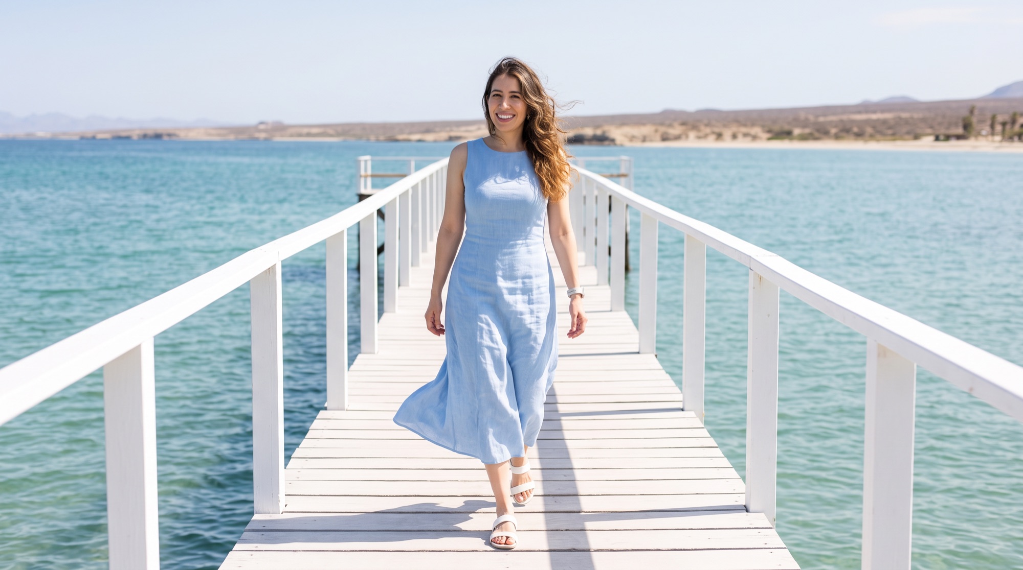 Andrea Ayon caminando por un muelle blanco sobre el mar turquesa de Baja California Sur